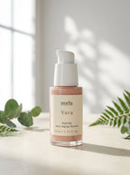 Vera Peptide Anti-Aging Serum 30 ml by Norla, glass pump bottle on a marble surface in soft daylight with fern leaves